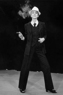 Image montrant le Smoking par Yves Saint-Laurent, porté par une femme en train de fumer.